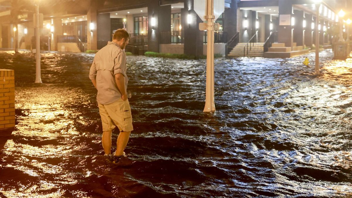 Brandon Marlow walks through surge waters flooding the street after Hurricane Milton came ashore in the Sarasota area in Fort Myers، Florida، on October 09، 2024.